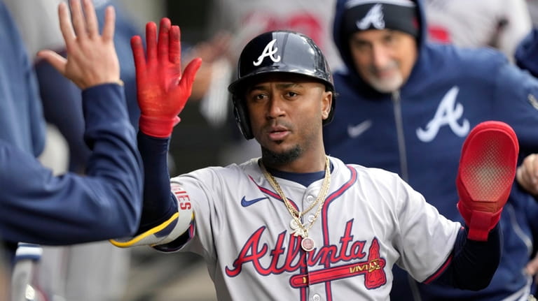Atlanta Braves' Ozzie Albies celebrates in the dugout after scoring...