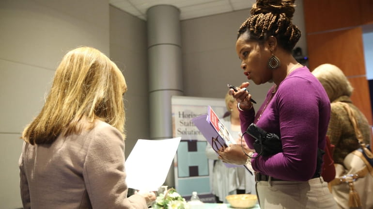 Job seeker Althea Woodhouse, right, of Uniondale, speaks with recruiter...
