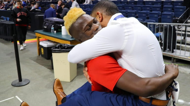 Long Beach's Dunia Sibomana hugs his coach and adoptive father,...