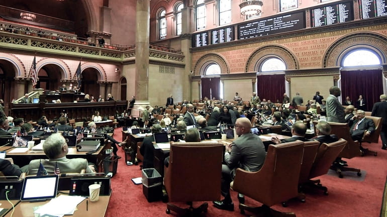 Members of the New York state Assembly vote on legislation during...