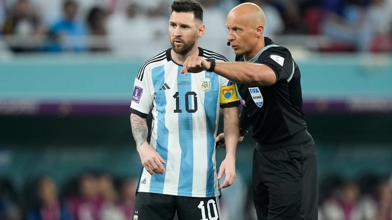 Referee Szymon Marciniak gestures as he speaks with Argentina's Lionel...