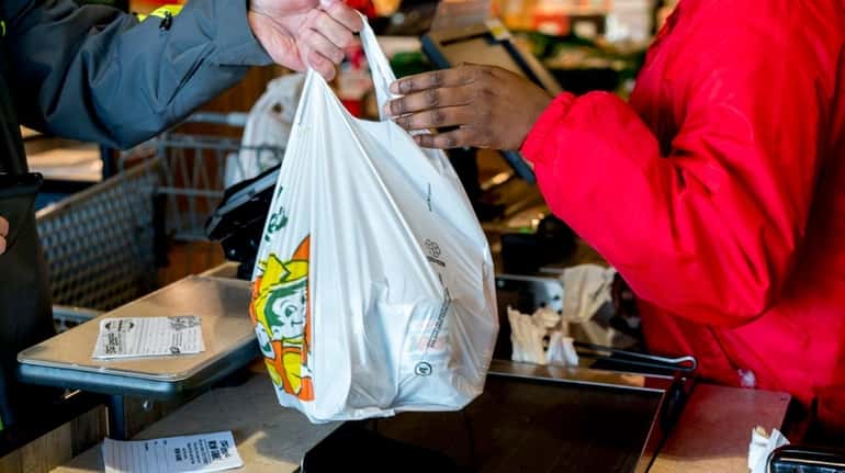 A cashier hands a shopper a plastic bag at Stew...