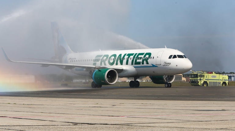 A Frontier Airlines flight from Orlando is sprayed with water...