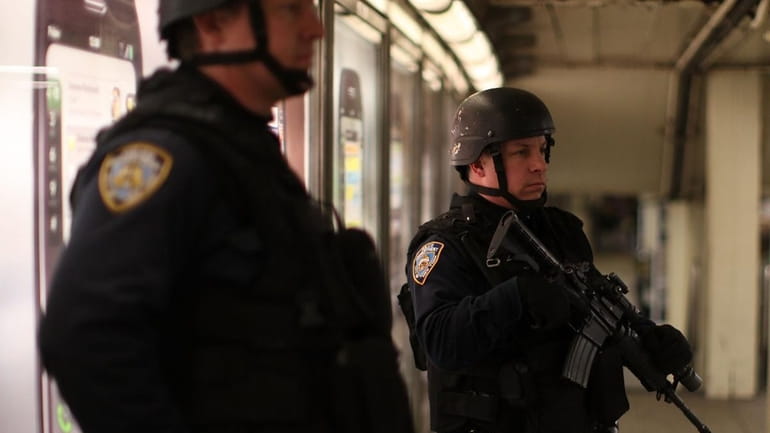 Police stand guard in a New York City subway station....