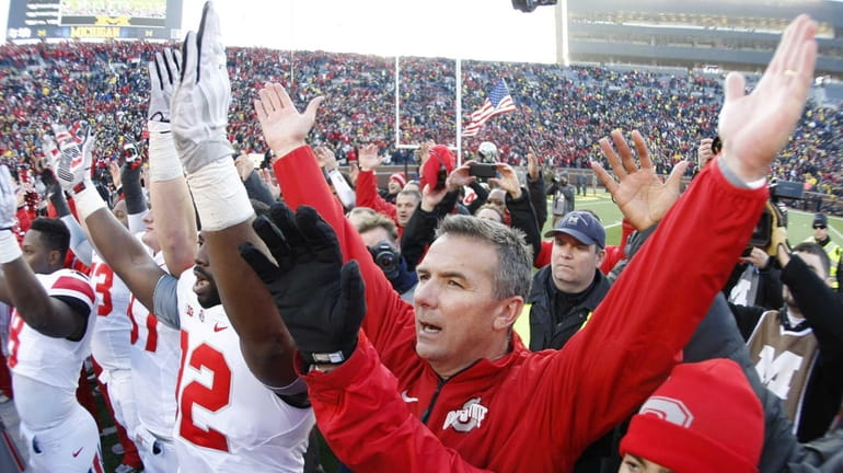 Ohio State head coach Urban Meyer joins his team in...