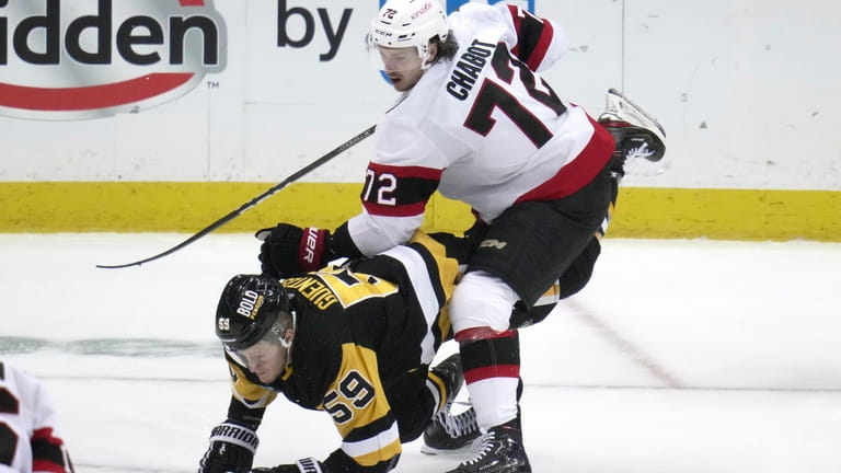 Pittsburgh Penguins' Jake Guentzel (59) is upended by Ottawa Senators'...