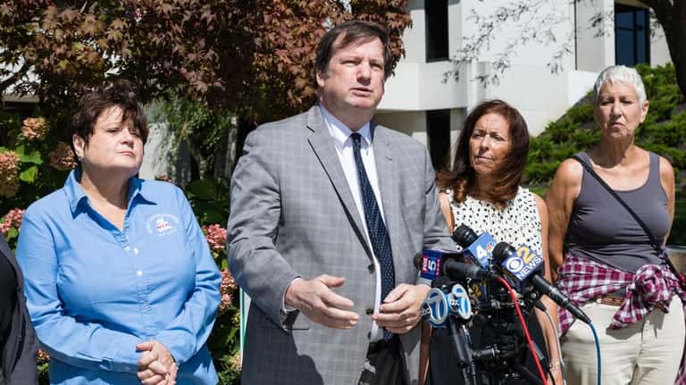 Attorney Christopher Murray, second from left, and Adrienne Esposito, second from...