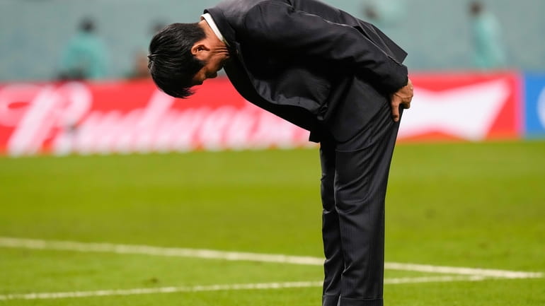 Japan's head coach Hajime Moriyasu bows after losing the penalty...