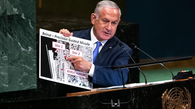 Israel Prime Minister Benjamin Netanyahu holds up a sign that...