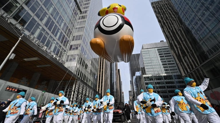 Pikachu and its team of balloon handlers make their way...