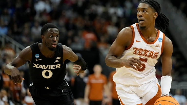 Texas guard Marcus Carr drives to the basket past Xavier...