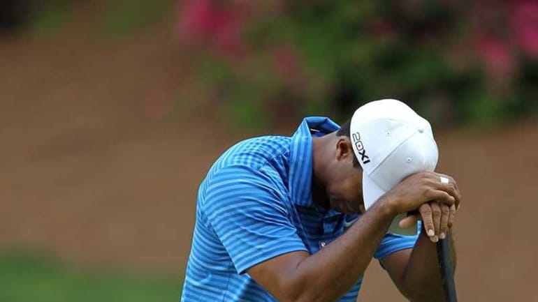 Tiger Woods reacts to a missed putt on the 13th...