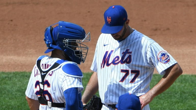 Mets catcher Robinson Chirinos talks to starting pitcher David Peterson...