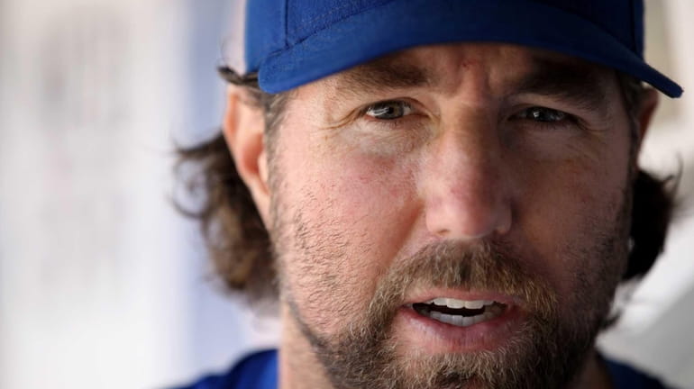 Mets pitcher R.A. Dickey talks in the dugout at Citi...