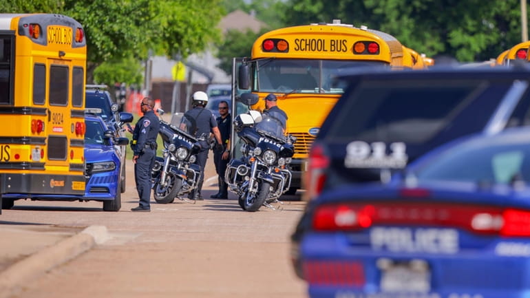 Police officers prepare to escort students to be reunited with...
