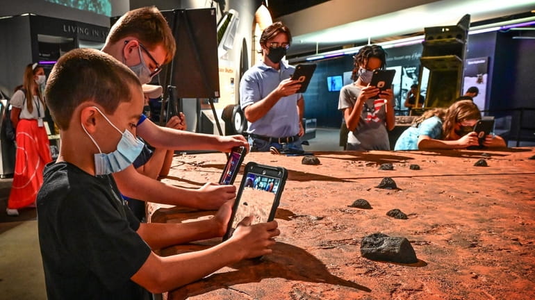 Frankie Harris, 10, uses a tablet to access the Mars Augmented...
