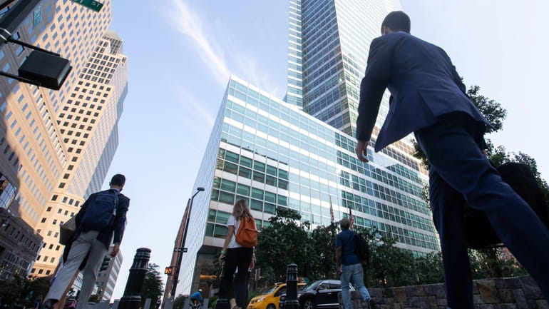 Office workers walk near the Goldman Sachs Group headquarters in...