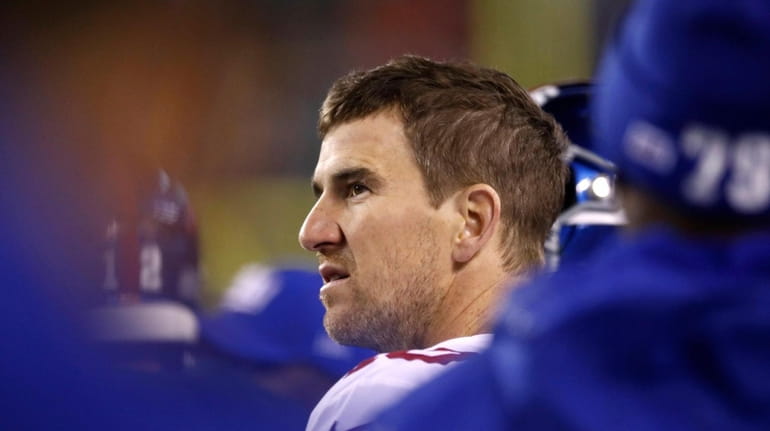 The Giants' Eli Manning looks on from the sidelines during...