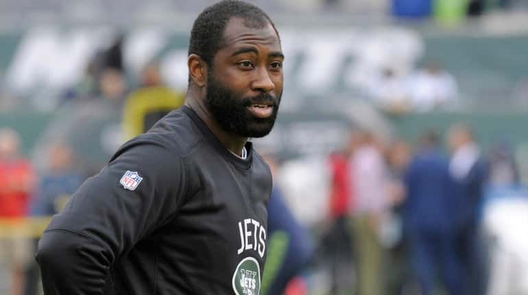 Jets cornerback Darrelle Revis warms up before an NFL football...