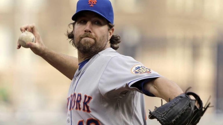 Mets pitcher R.A. Dickey throws during the first inning of...