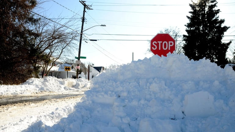 A pile of snow nearly covers a stop sign Monday...