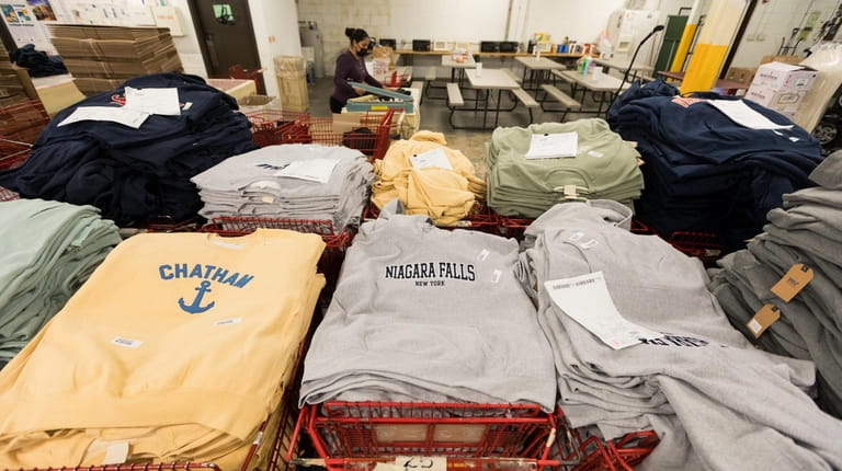 Embroidered sweatshirts are stacked in shopping carts at David Peyser...