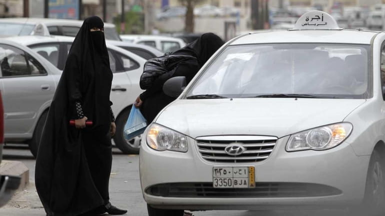 Saudi women board a taxi in Riyadh in May. Women...