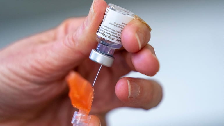 A COVID vaccine is prepared for use. The Centers for...