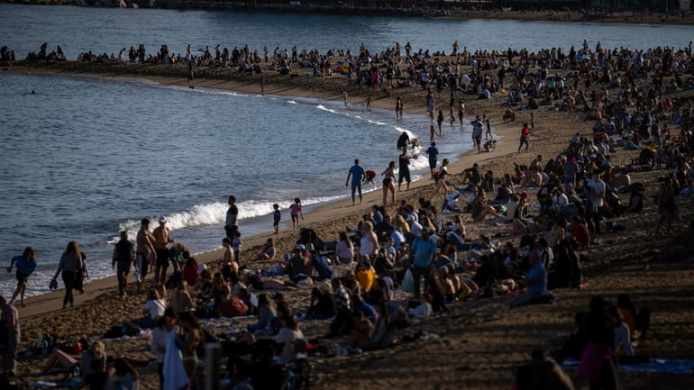 People sunbathe on a beach in Barcelona, Spain, Sunday, March...