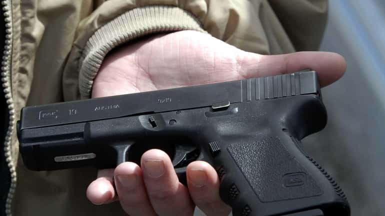 A firearms owner displays a Glock 9-mm pistol in Roanoke,...