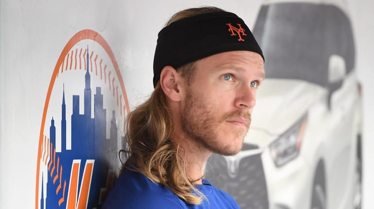 Mets pitcher Noah Syndergaard looks on from the dugout during...