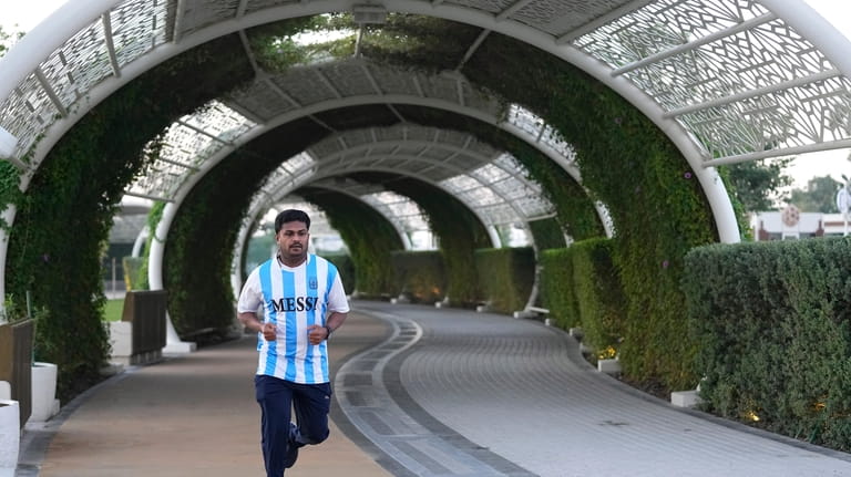 A fan in a Messi jersey runs at Al Gharafa...