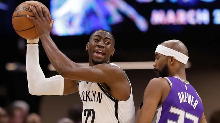 Nets guard Caris LeVert, left, protects the ball from Kings...