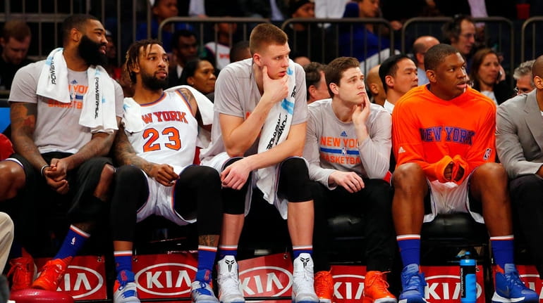 The New York Knicks bench looks on late in a...