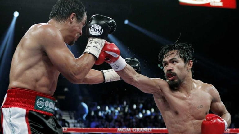 Manny Pacquiao, right, of the Philippines, hits Mexico's Juan Manuel...