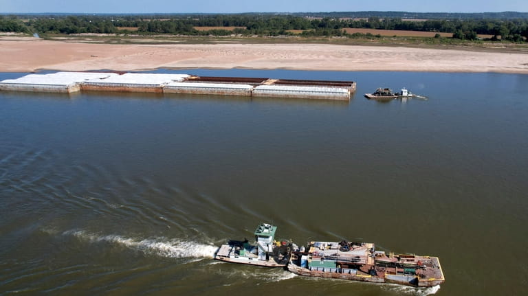 Tugboats work in low water levels along the Mississippi River,...
