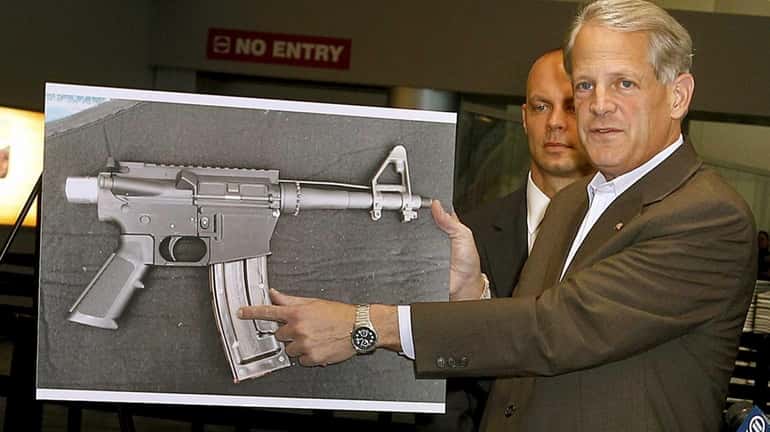 Holding up a photo of a plastic AR-15 automatic weapon,...