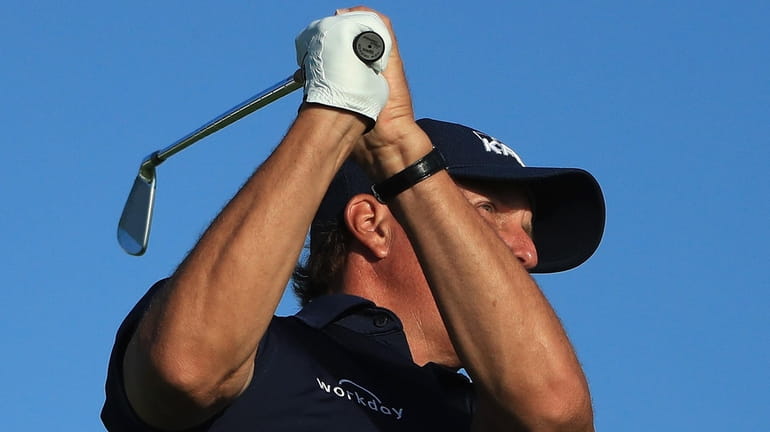 Phil Mickelson plays his shot from the 11th tee during...