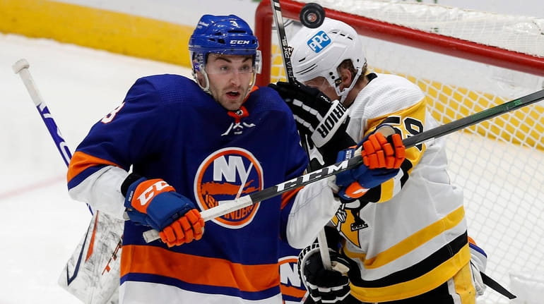 Adam Pelech of the Islanders keeps his eye on the puck during...