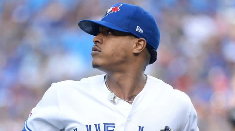 Marcus Stroman looks back as a teammate makes a catch for...
