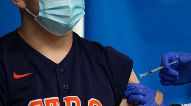 Astros fan Jose Ramos receives a COVID-19 vaccination at the...