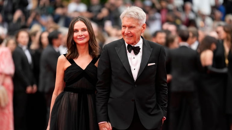 Calista Flockhart and Harrison Ford walk the red carpet ahead of the...