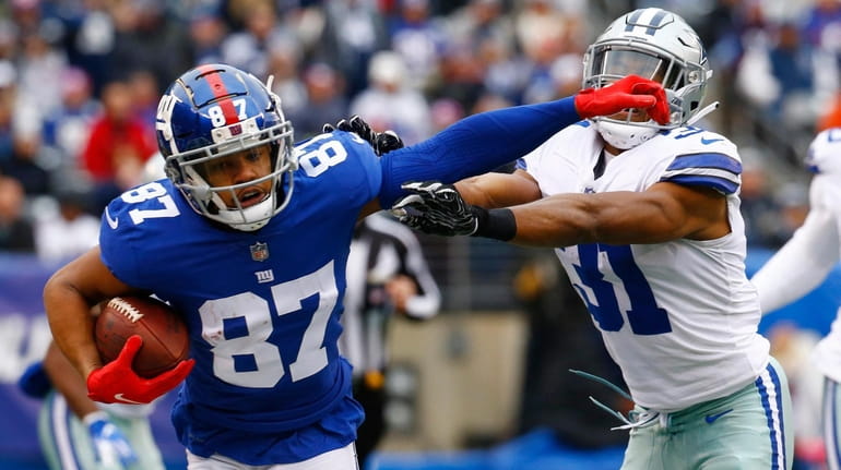 Sterling Shepard of the Giants stiff-arms Byron Jones of the...