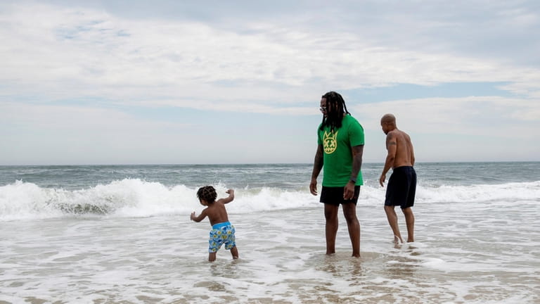 Daylan Gentry, 2, plays in the water at Ocean Beach alongside...
