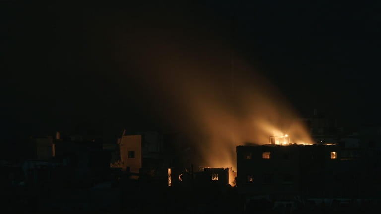Flames engulf a building following an Israeli airstrike in the...