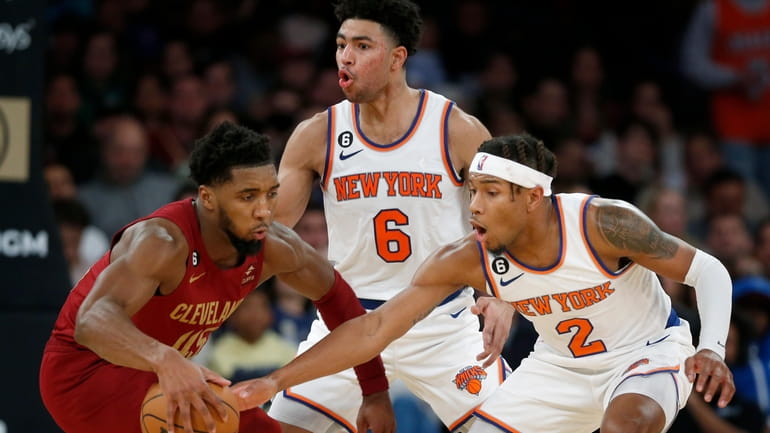 Cleveland Cavaliers guard Donovan Mitchell, left, is defended by New...
