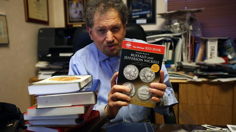 Dr. David Menchell displays "The Official Red Book - A...