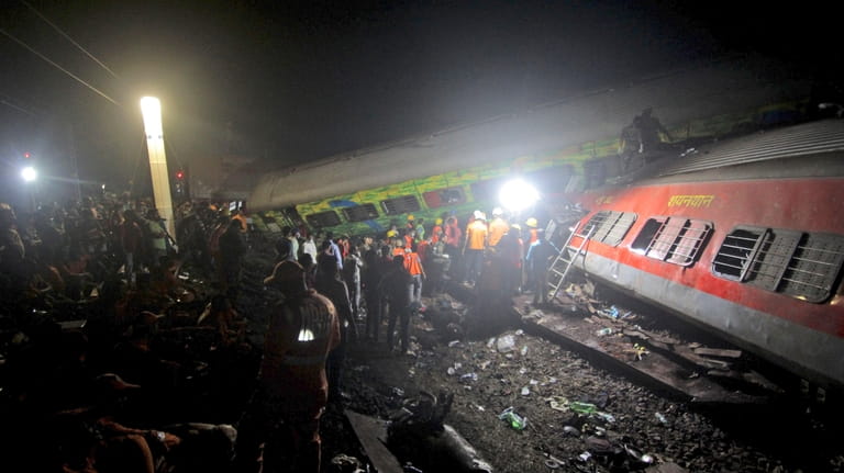 Rescuers work at the site of passenger trains accident, in...
