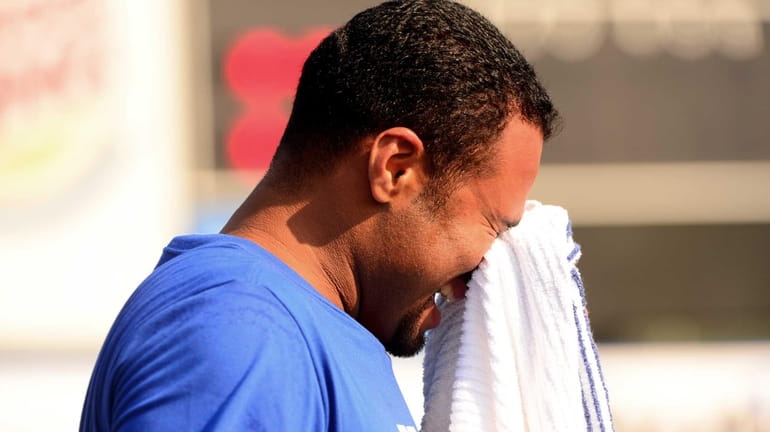Johan Santana wipes his face after playing catch during a...