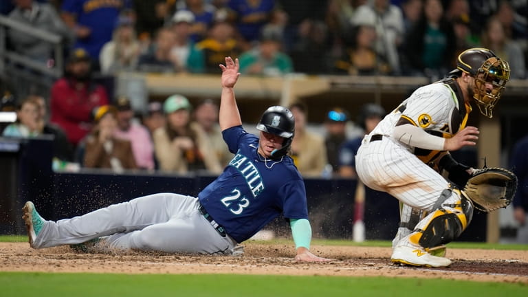 Seattle Mariners' Ty France (23) scores from second base off...